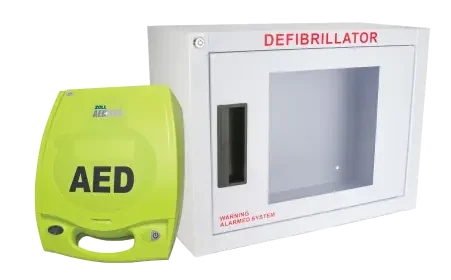Defibtech Lifeline AED beside a wall-mounted alarmed defibrillator cabinet